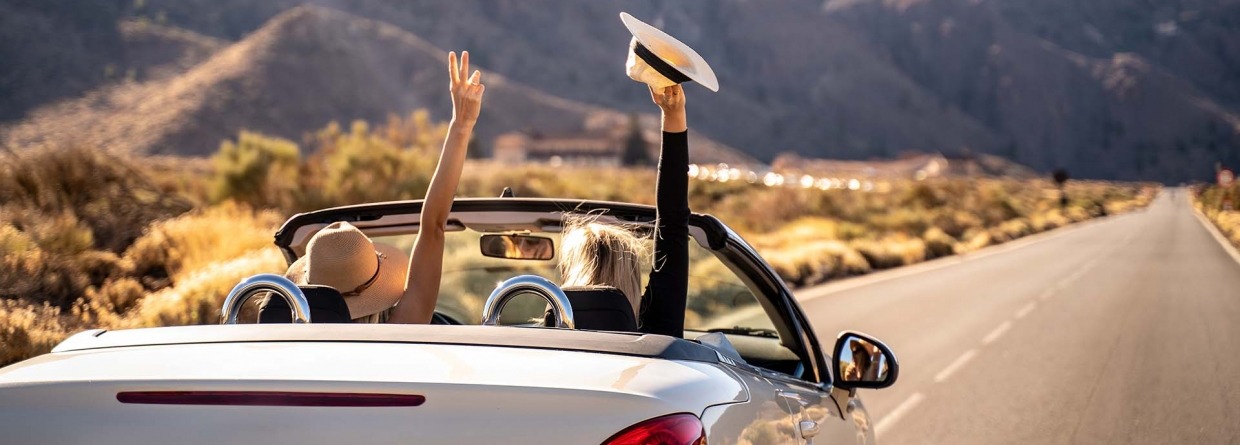 Autorondreis; twee vrouwen in een cabrio rijden door de bergen