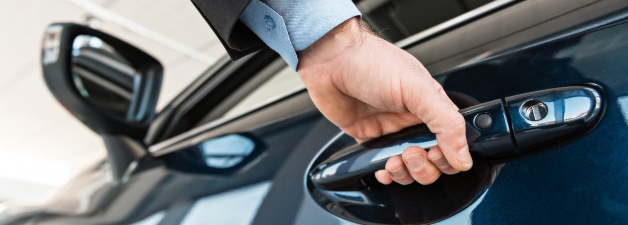 Man doet pakt portier van auto vast