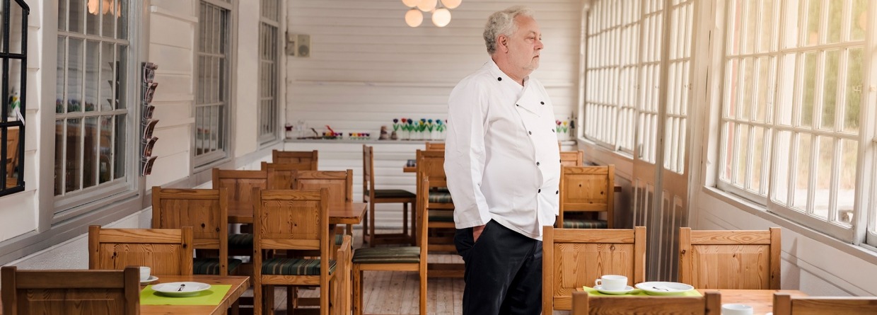 Bezorgde restauranteigenaar die zich in zijn leeg restaurant bevindt