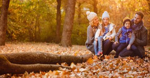 Een gezin in het bos tijdens de herfst
